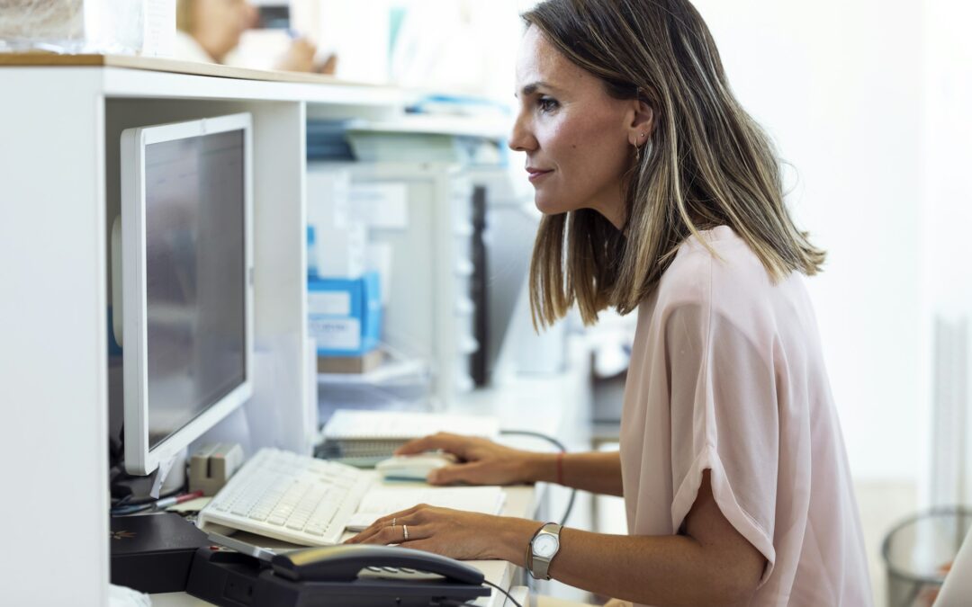 Woman working on computer at reception desk
